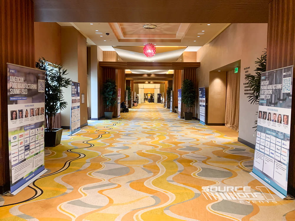 Freestanding event banner welcoming attendees inside a conference venue.