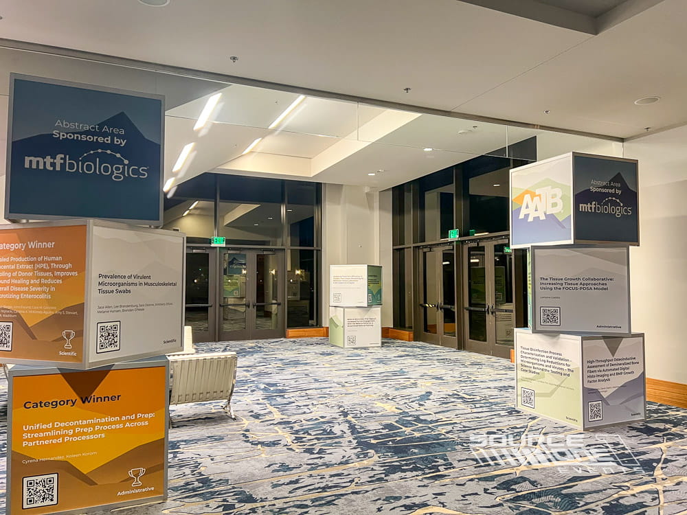 Modern stacked cube display with custom branded graphics creating an eye-catching conference wayfinding feature.