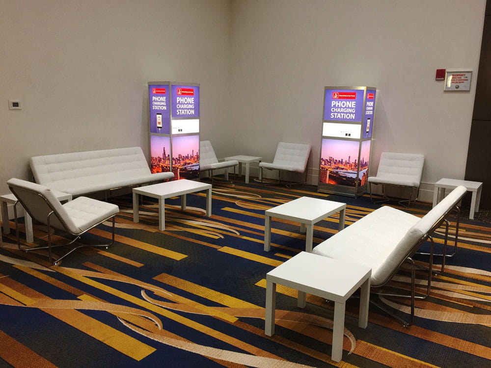 Executive hospitality suite with lounge seating and branded event signage