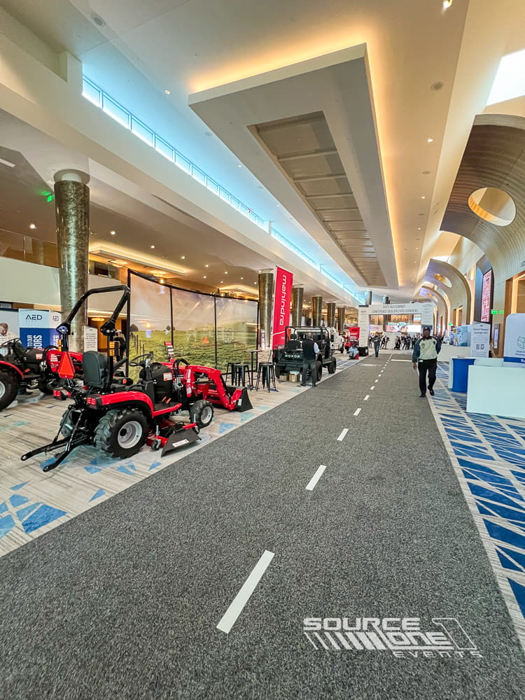 Branded aisle carpet installed throughout a convention center exhibit hall.