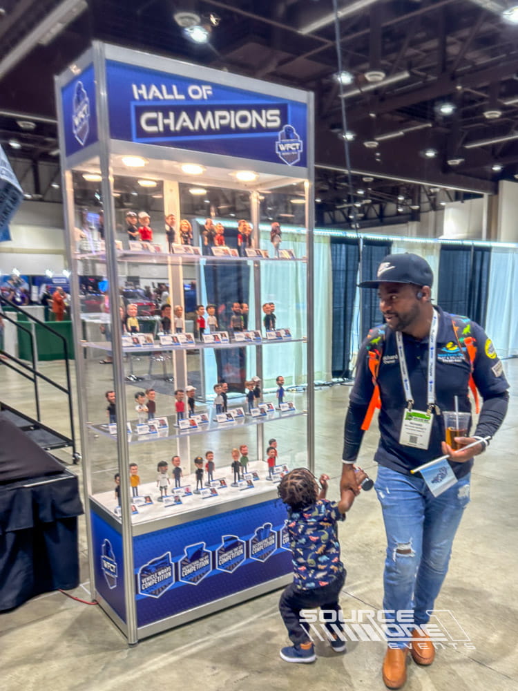 Large branded display case showcasing products and awards inside a trade show exhibit designed for attendee engagement.