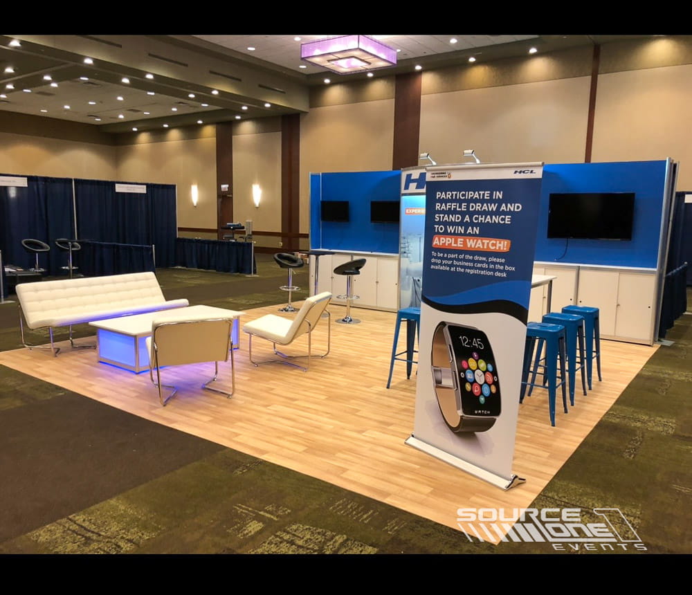 Technology exhibit featuring blue and white branded counters, meeting tables, and premium custom exhibit fabrication.