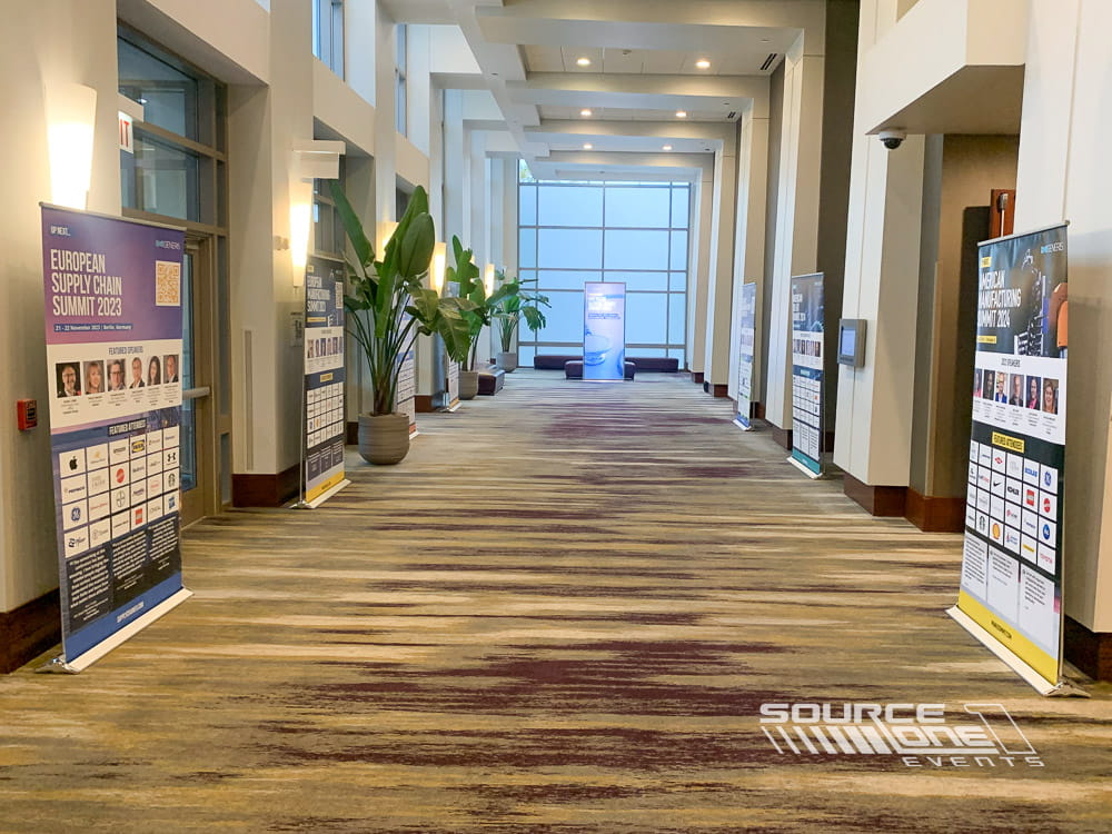 Banner stands lining a convention center corridor to welcome and guide conference attendees.