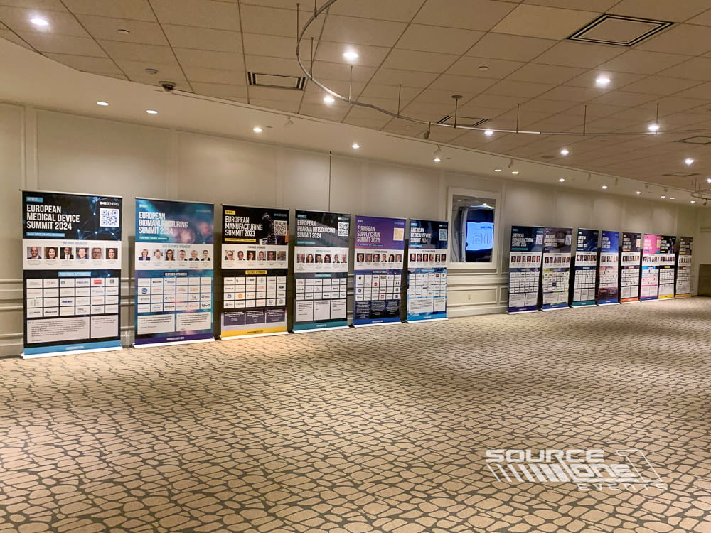 Series of branded banner stands showcasing conference sponsors and event information.