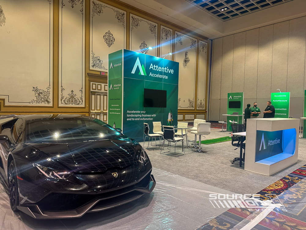 Wide-angle view of custom software exhibit with illuminated branding, meeting stations, and interactive product demonstrations.