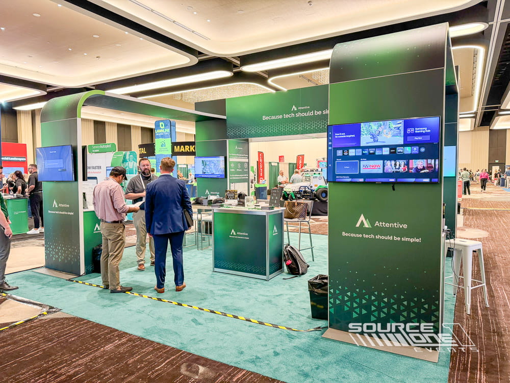 Bright green custom exhibit featuring digital displays, product demonstrations, and modern exhibit architecture for software solutions at a trade show.