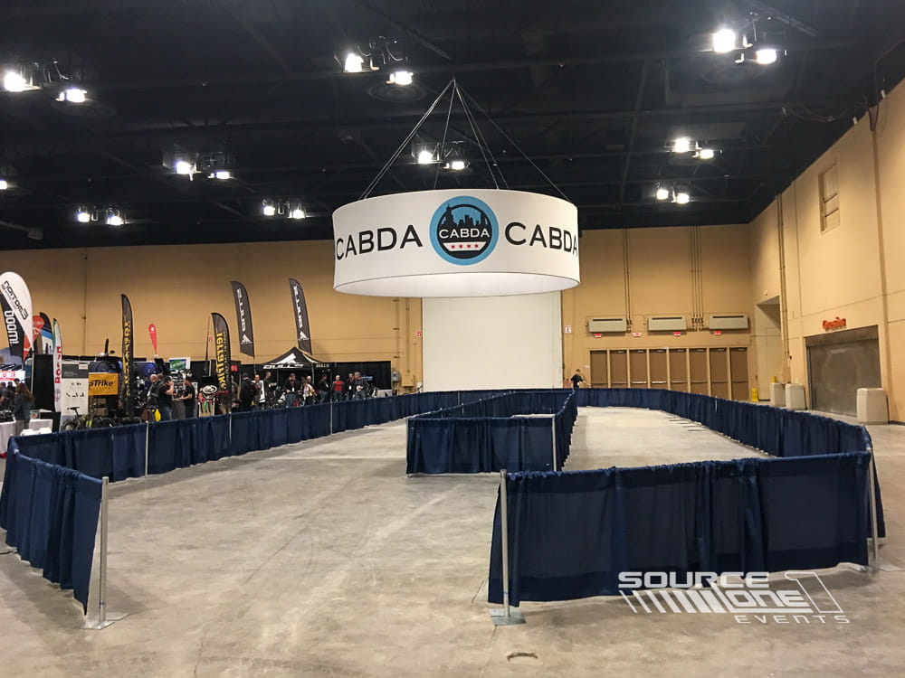 Indoor bicycle demonstration area with branded overhead signage and custom event graphics for attendee product testing.