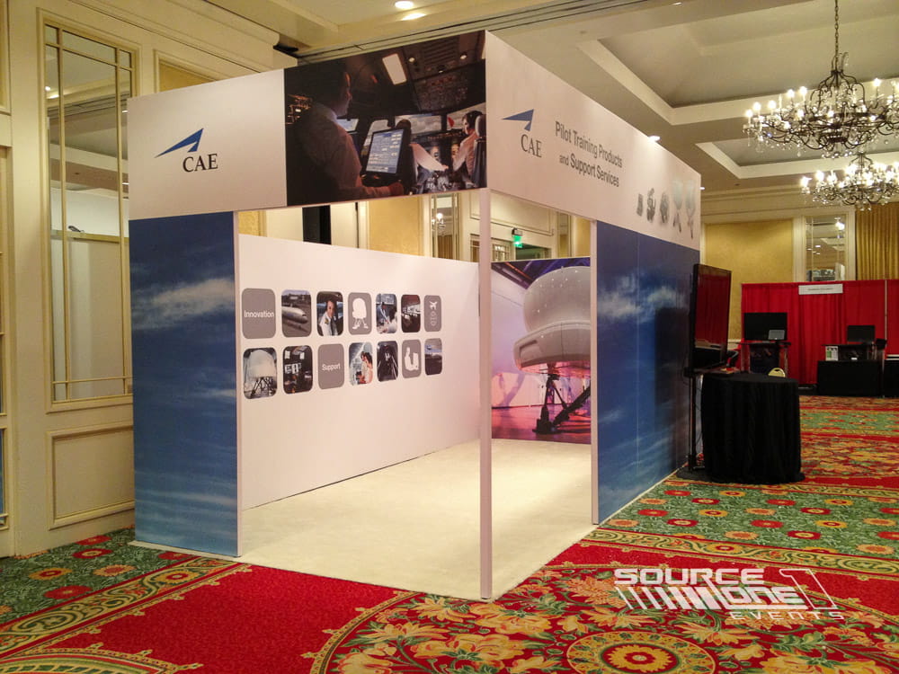 Contemporary custom exhibit featuring illuminated graphics, curved exhibit walls, and open attendee engagement areas with premium exhibit construction.