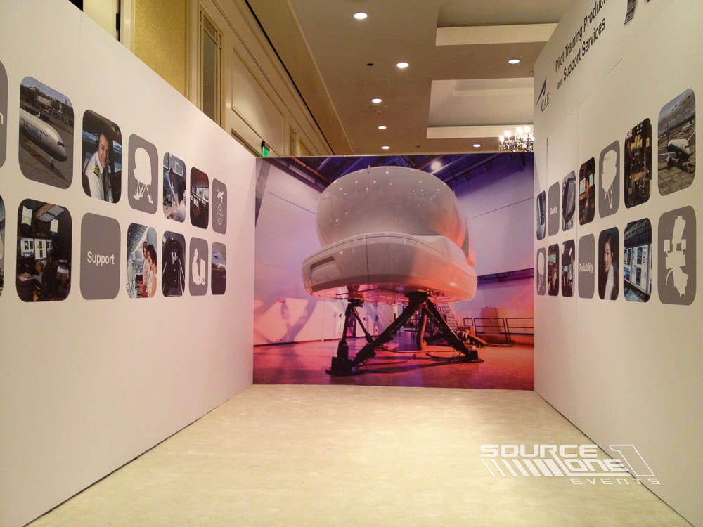 Large custom trade show booth with curved architectural elements, suspended graphics, product displays, and immersive brand storytelling.