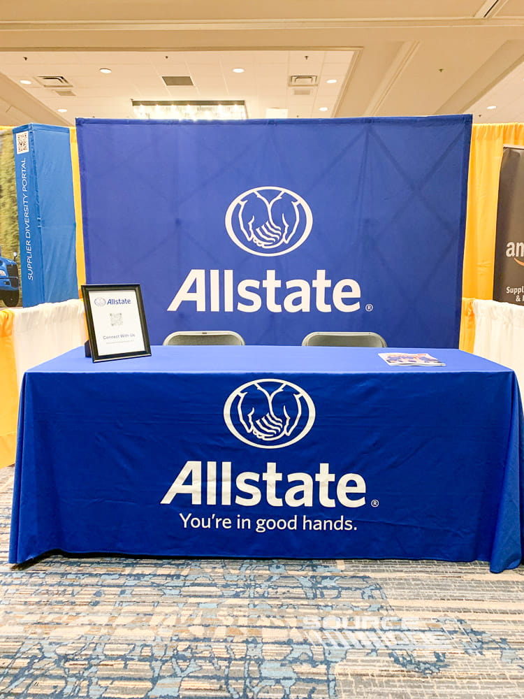 Allstate-branded exhibit table with custom printed table throw designed for conference registration and attendee interaction.