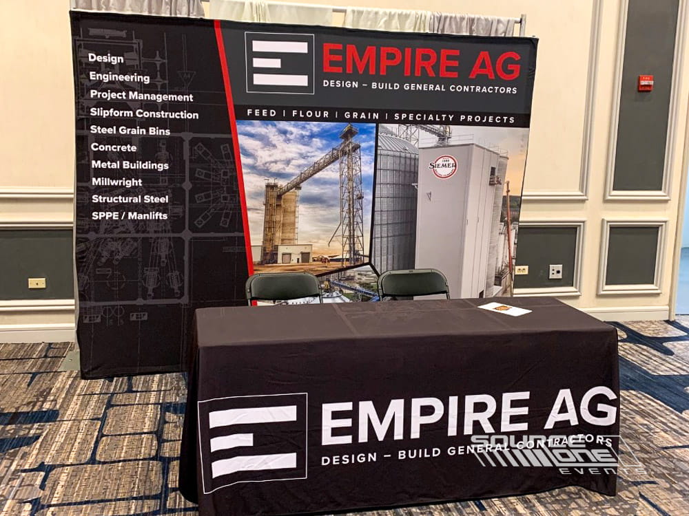 Empire AG custom exhibit table featuring branded table throw, product information, and promotional display graphics.
