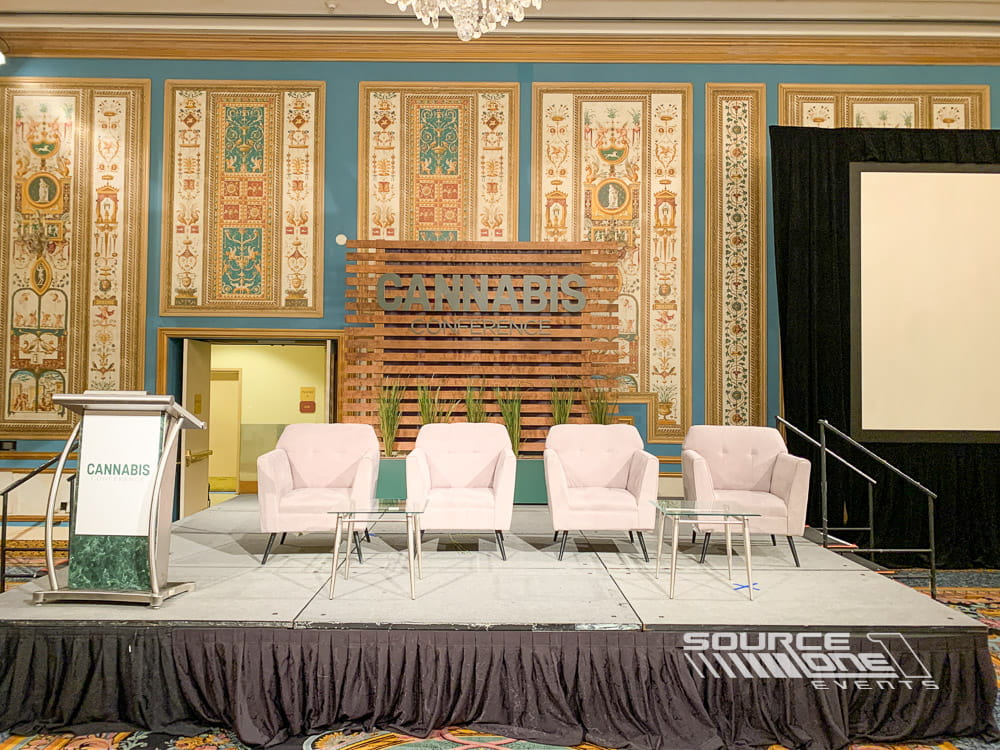 Educational conference stage with white seating, scenic backdrop, and professional event production for industry presentations.