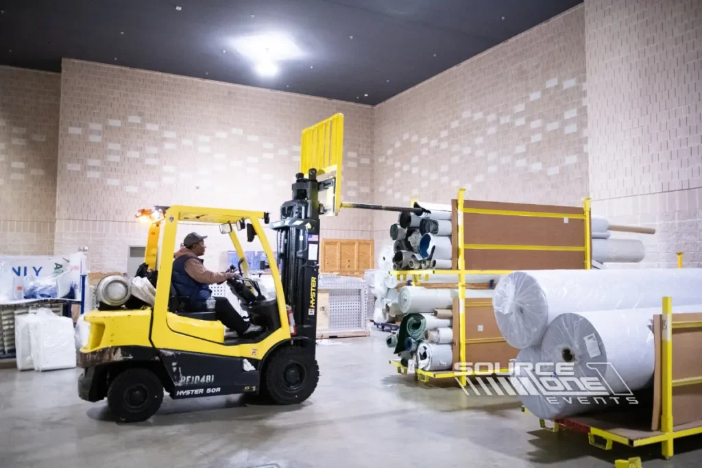 Industrial exhibit booth featuring warehouse equipment and forklift display.