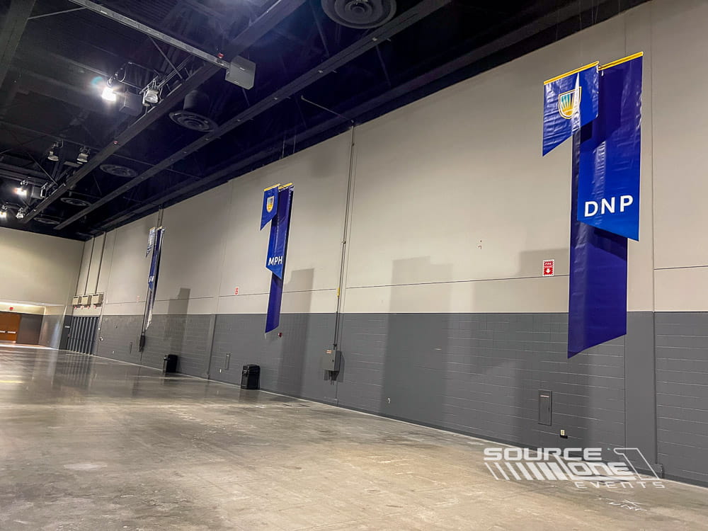 Suspended branded signs guiding attendees through the trade show while increasing exhibitor visibility.