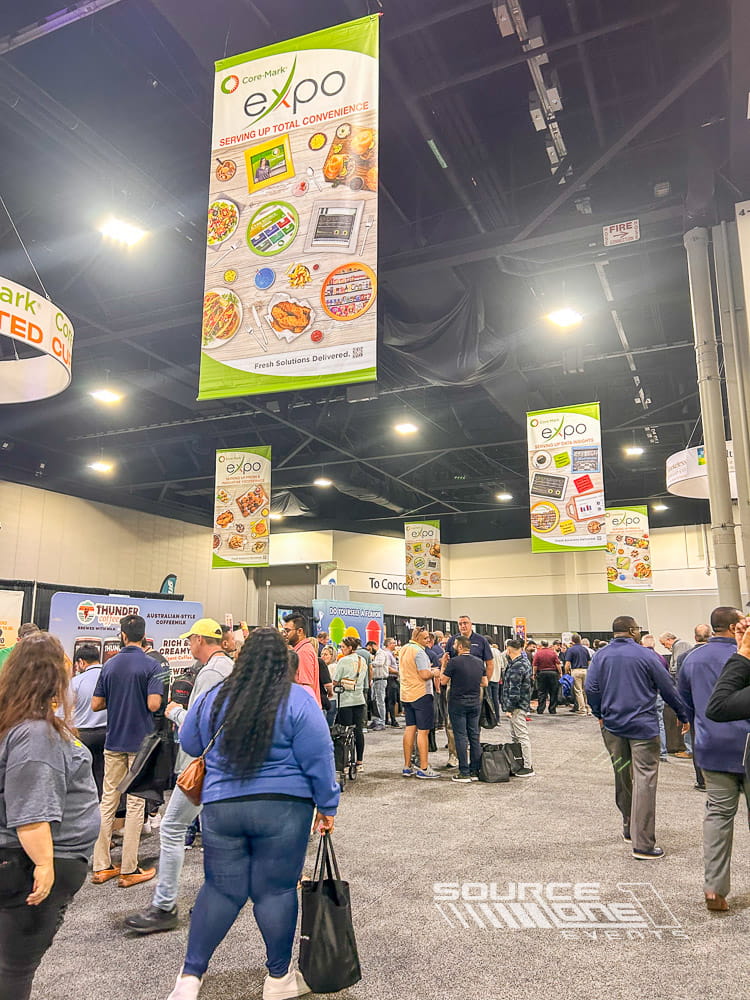Suspended circular hanging signs featuring Core-Mark branding above a busy trade show booth for maximum visibility.