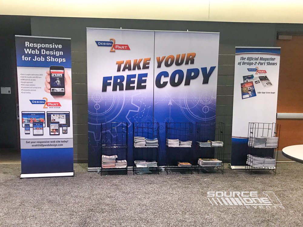 Promotional banner stand displaying conference information and printed materials.