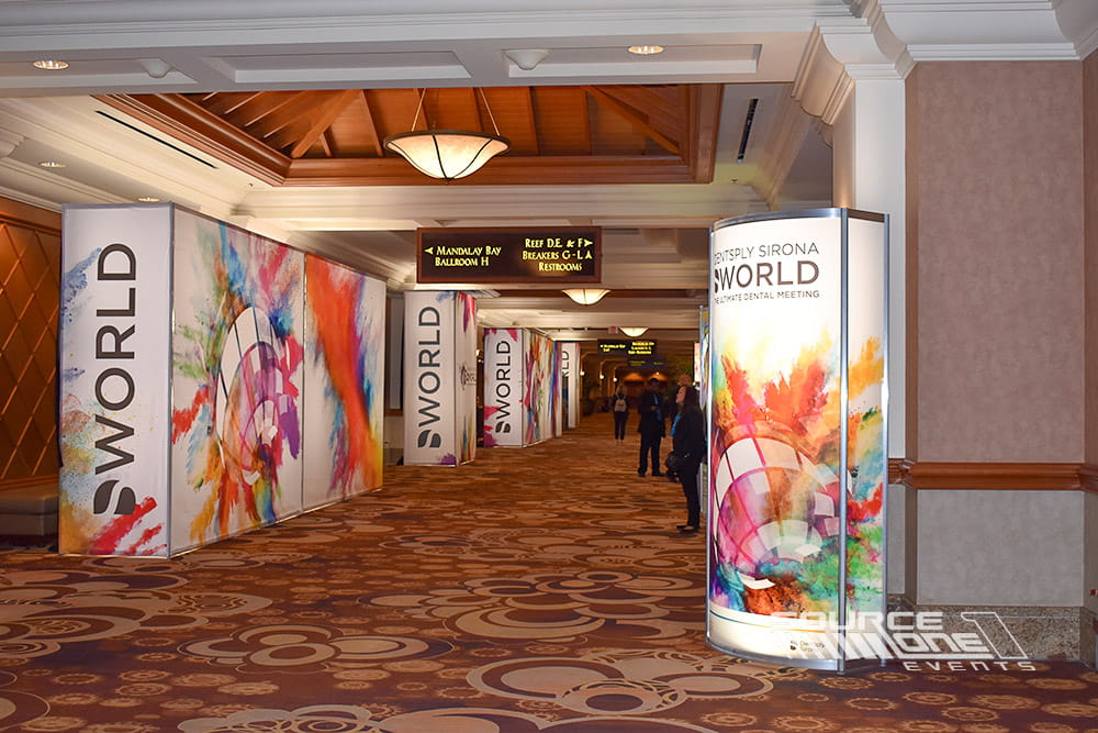 Colorful branded entrance walls with vibrant graphics creating an immersive conference arrival experience.