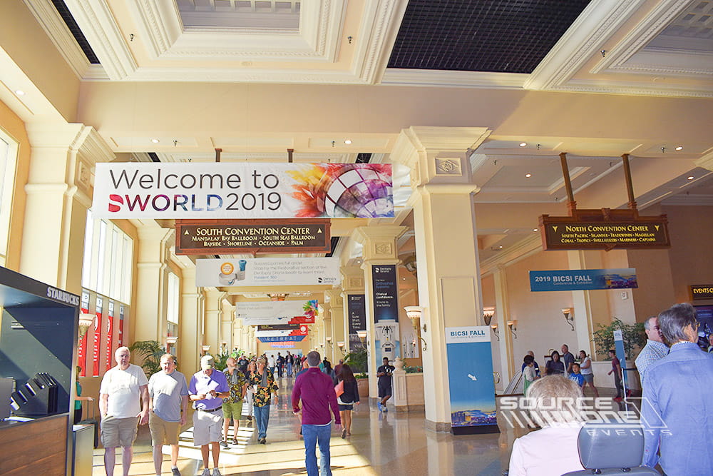 Large suspended conference graphics welcoming attendees and guiding traffic through the convention center.