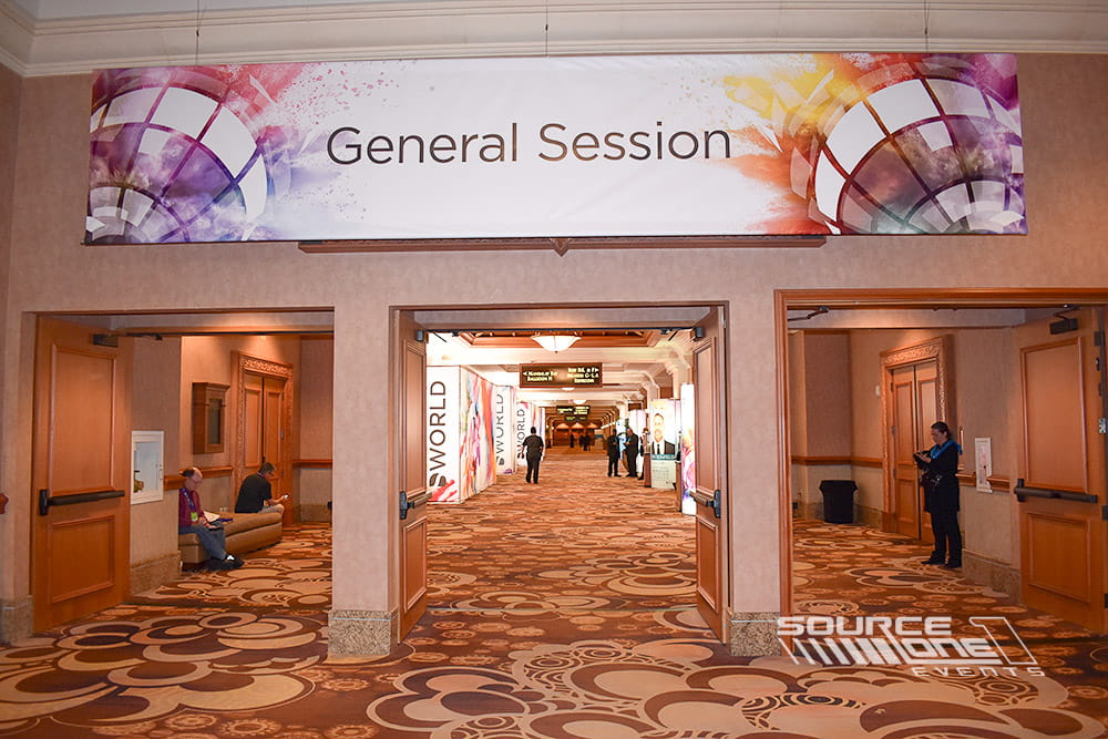 Elegant hanging banner positioned above a ballroom entrance displaying General Session branding and event graphics.