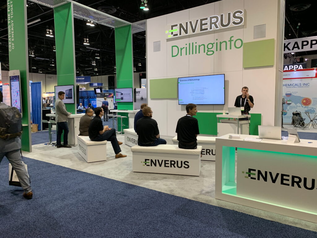 Custom trade show booth design with branded meeting space and digital displays