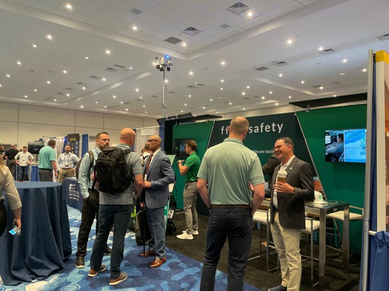 Trade show attendees networking on a busy exhibit floor surrounded by custom booths and branded displays.