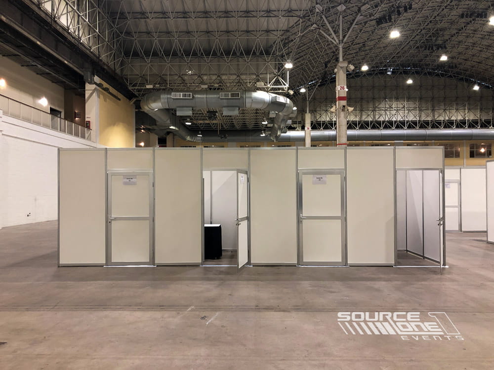 Extensive modular hard-wall booth system creating multiple private interview rooms within a convention center.
