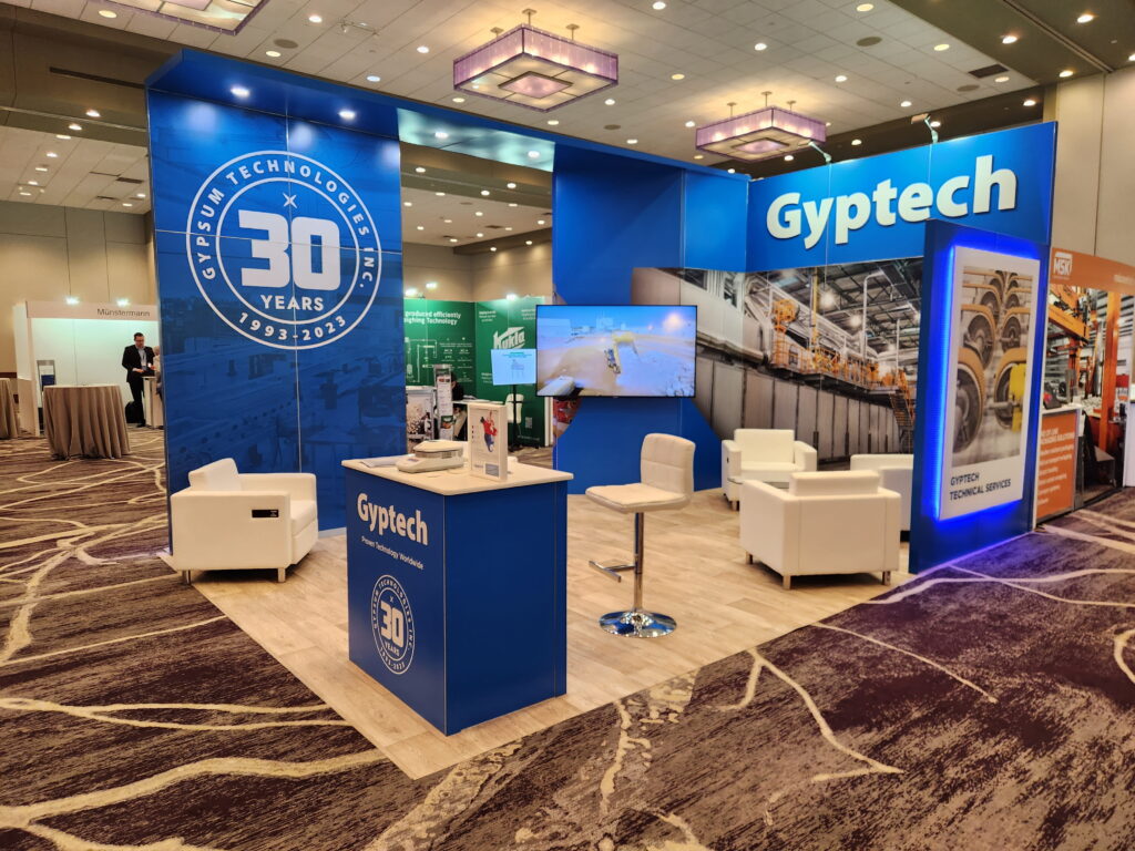 Modern blue custom exhibit showcasing product displays, illuminated branding, and corporate trade show architecture.