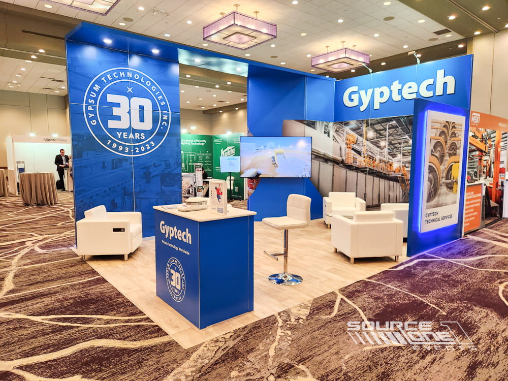 Modern custom exhibit showcasing equipment solutions through large-format graphics, digital media, and open exhibit design.
