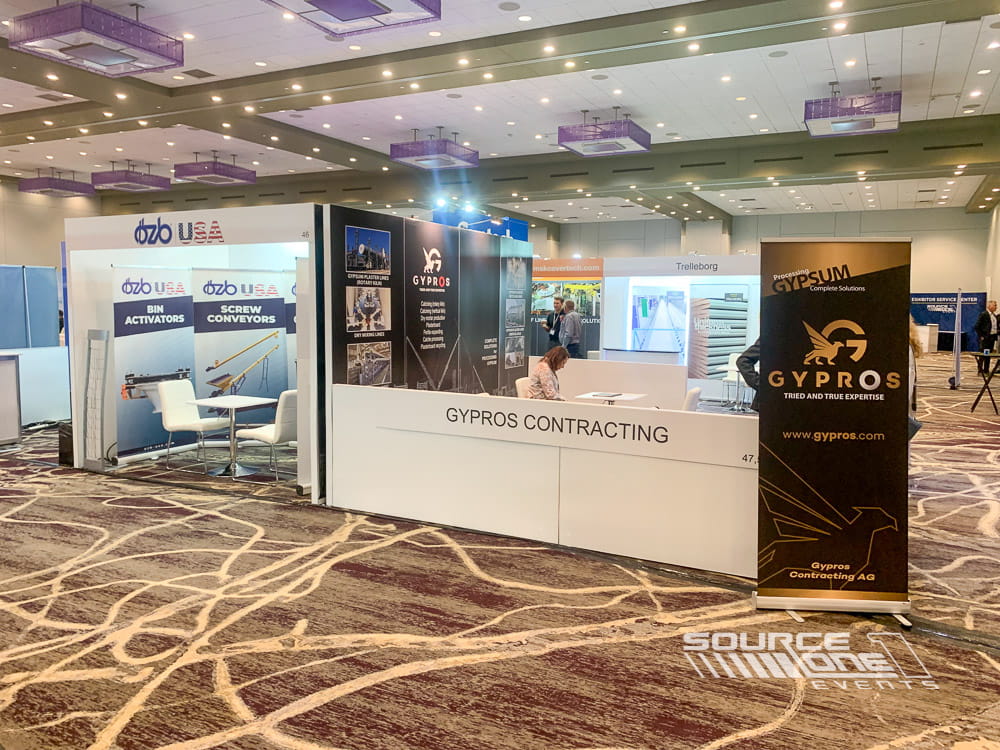 Modern hardwall exhibit featuring product displays, branded walls, and spacious attendee engagement area.