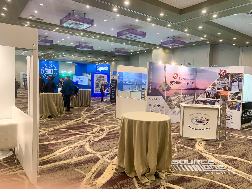 Large gypsum industry exhibit featuring white architectural walls, branded displays, and collaborative meeting areas.