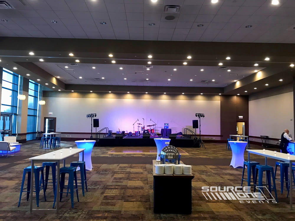 High-top tables and stools arranged for attendee networking and informal meetings at a conference event.
