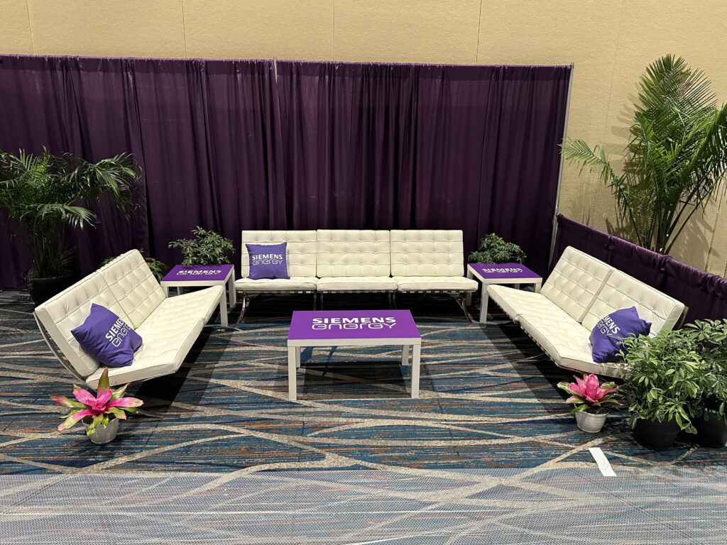 Lounge area with sofas and purple drapery for event networking.
