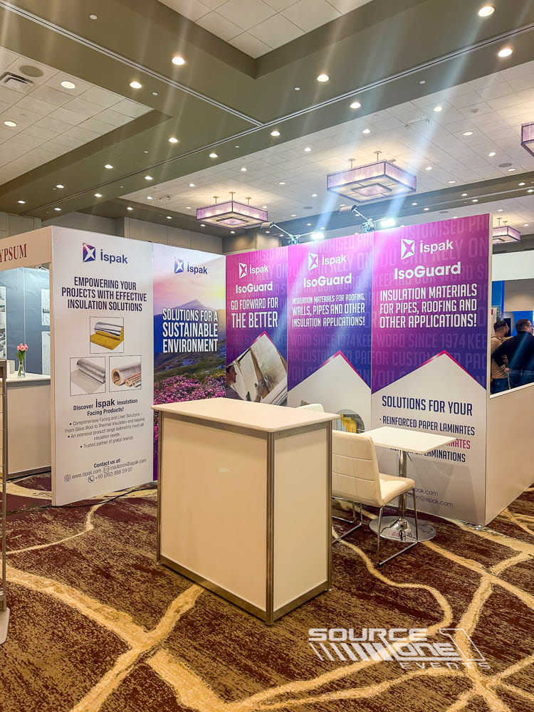 Colorful branded trade show booth featuring purple and white graphics, product messaging, and modern exhibit architecture.