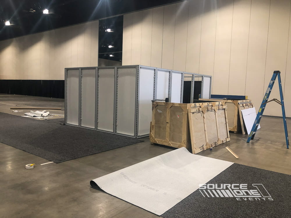 Large temporary hard-wall room installation providing flexible private meeting and conference space within an exhibition hall.