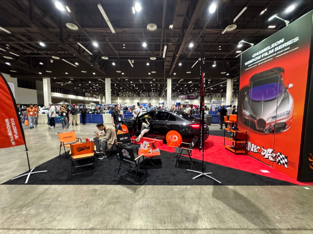 Automotive trade show booth with performance vehicle displays, bold branding, and open attendee engagement space.