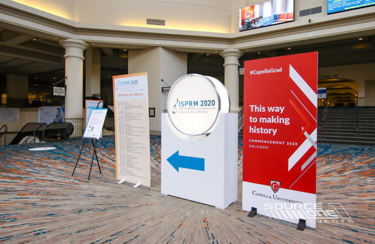 Illuminated circular backlit display showcasing conference branding and attendee messaging in a convention center.