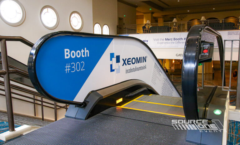 Branded escalator graphics extending conference branding throughout the convention center.