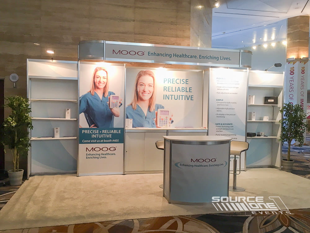 Corporate exhibit featuring custom graphics, illuminated branding, meeting areas, and product presentation displays.