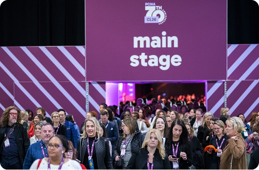 Attendees entering the PCMA Convening Leaders main stage through a custom purple branded entrance tunnel with large-format event graphics.