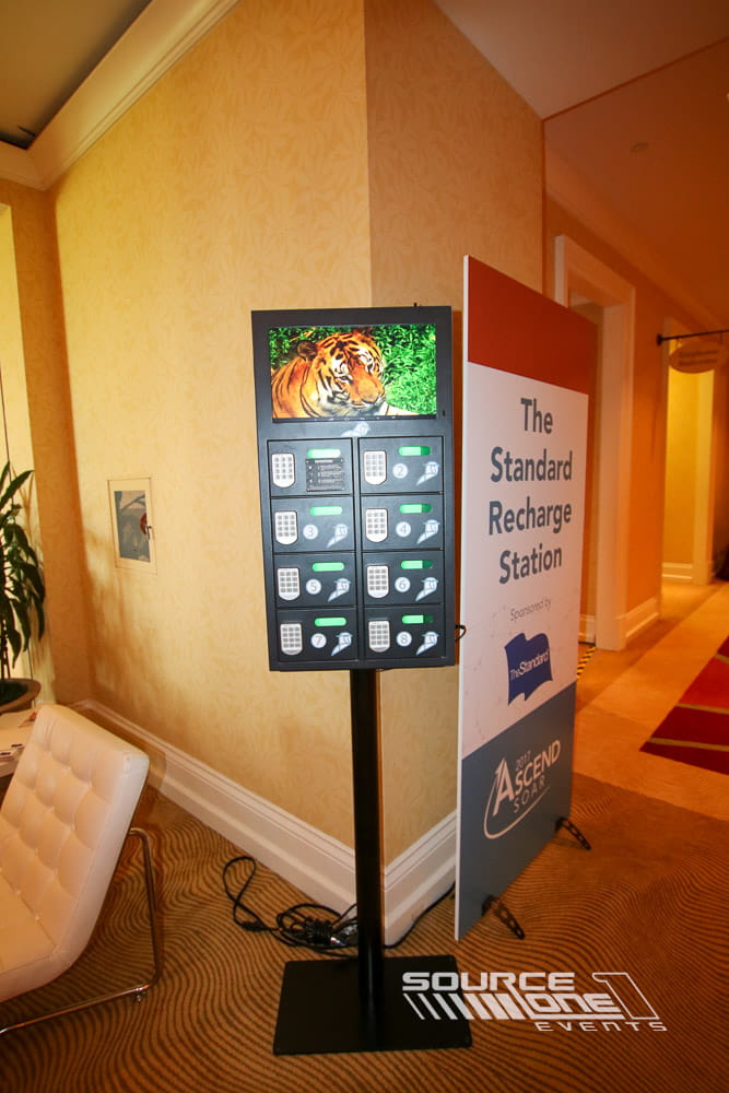 Custom charging locker station with digital touchscreen, wood finishes, and branded event graphics for secure attendee device charging.