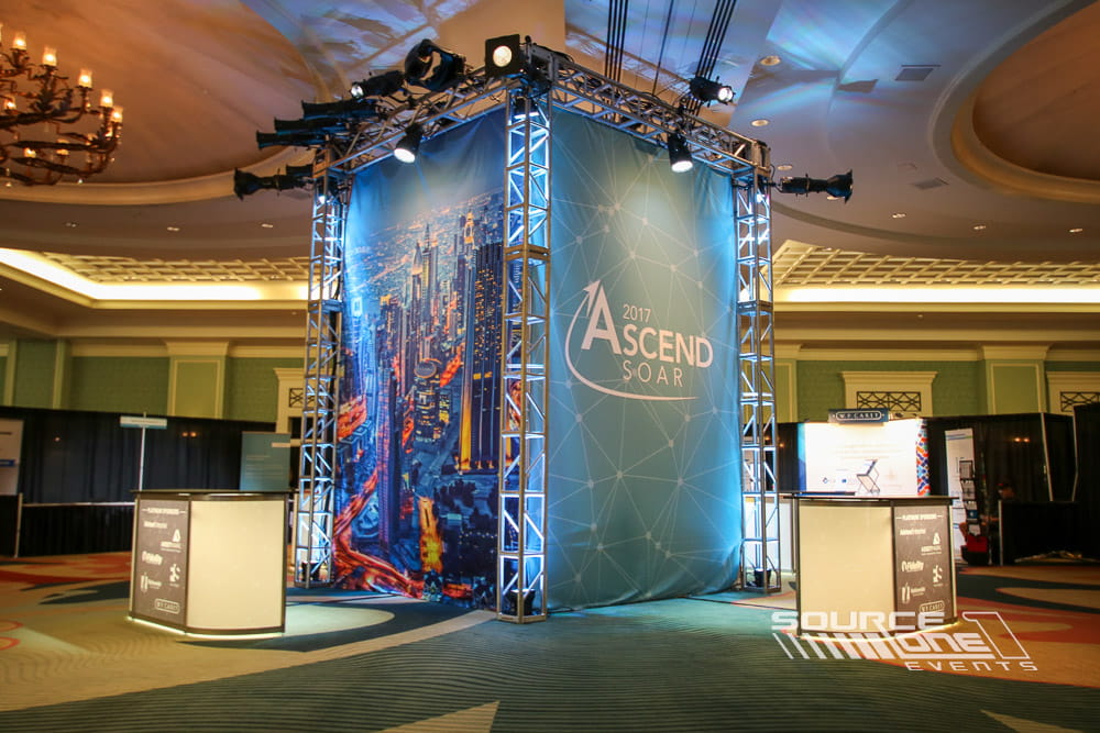 Multi-level custom exhibit featuring overhead lighting, digital media, scenic graphics, and open attendee interaction spaces.