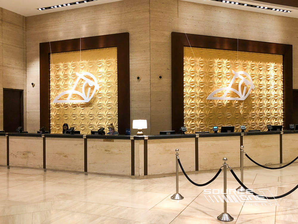 Illuminated hanging banners displaying event branding inside a conference venue.