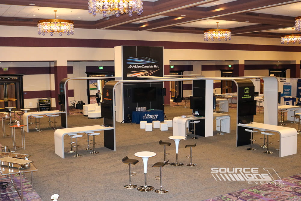 Elegant trade show booth with custom architectural elements, reception counters, and branded meeting areas.