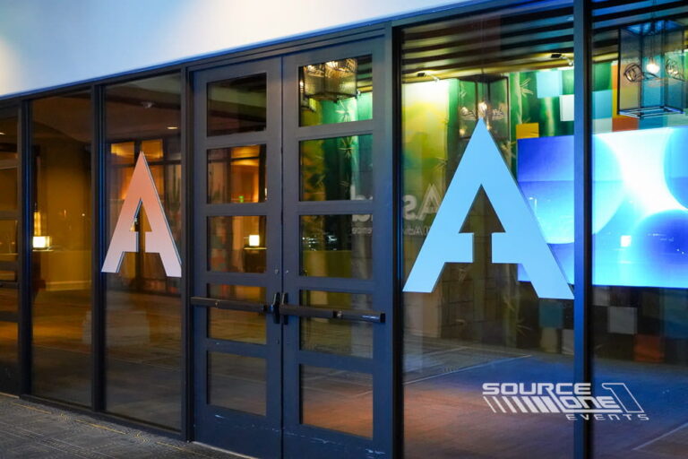 Large blue and green custom window graphics with oversized letterforms creating a striking environmental graphic installation.