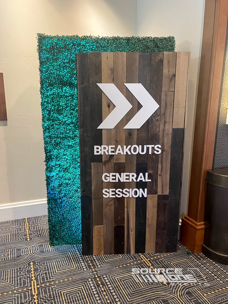 Branded directional sign guiding attendees to breakout sessions and conference programming.