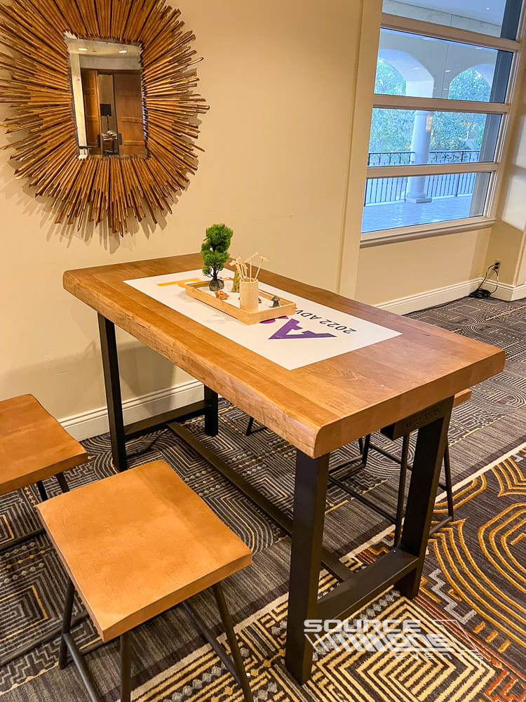 Modern networking table with wood finish and built-in technology supporting conference collaboration.