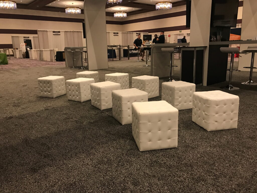 Event lounge area with white cube seating arranged in rows.