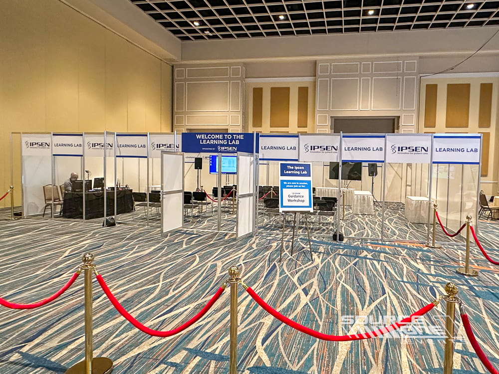 Custom laboratory exhibit with glass partitions, branded entry signage, and professional demonstration environment for attendees.