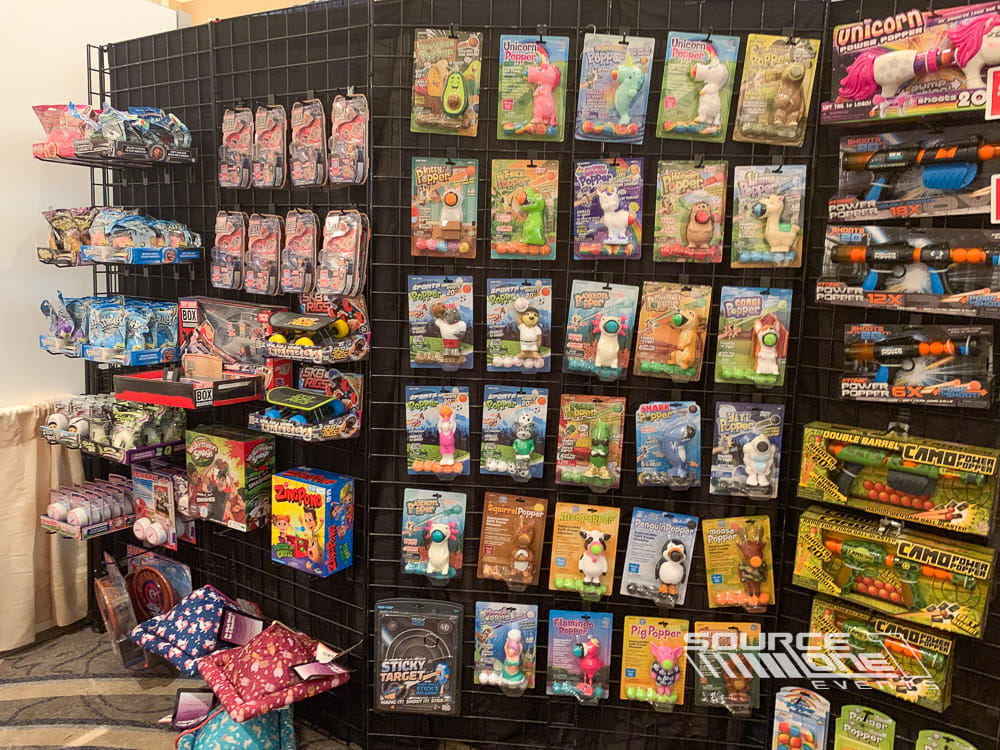 Retail display wall showcasing collectible products and merchandise using modular grid wall systems at a trade show.