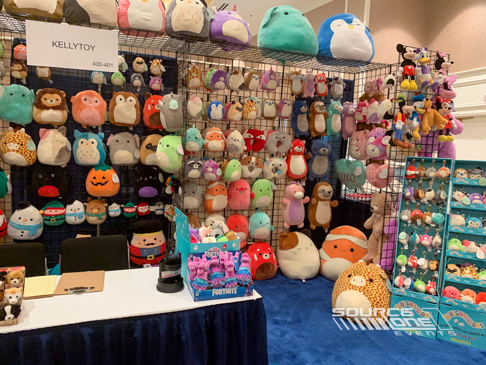 Bright merchandise display wall featuring plush toys organized on modular grid wall systems for retail trade show exhibits.